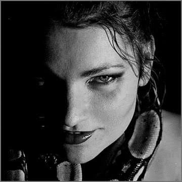 Schwarz-Weiß-Porträt einer Frau mit dunklem Blick, halb im Schatten
