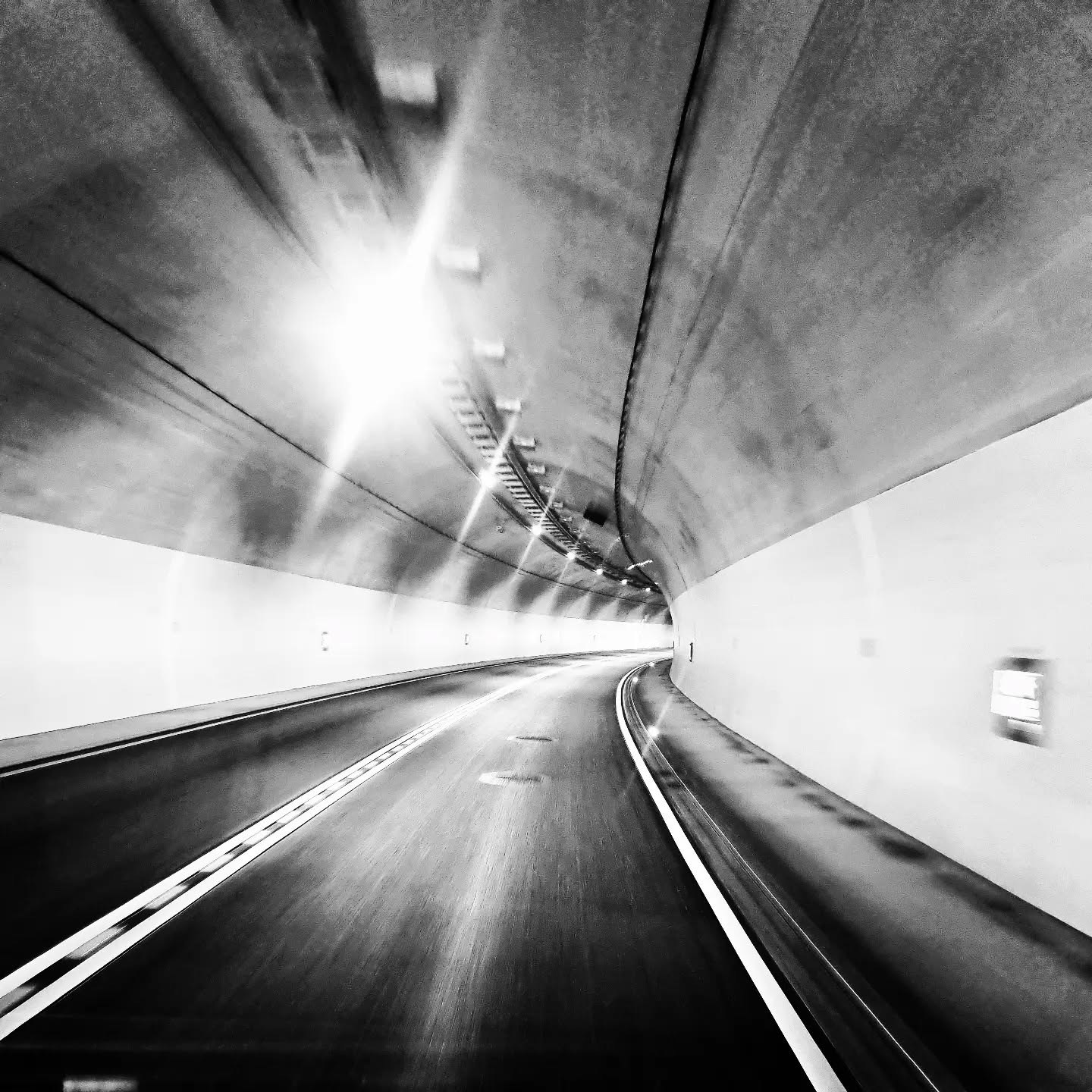 Tunnelwand mit Lichtern im Vorbeifahren, Schwarz-Weiß