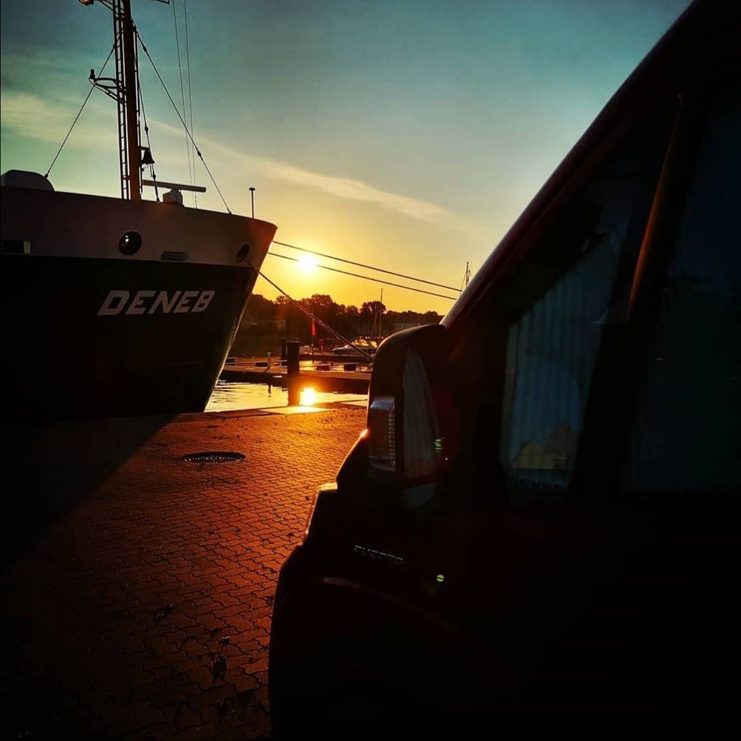 Sonnenaufgang am Hafen neben einem Schiffsrumpf