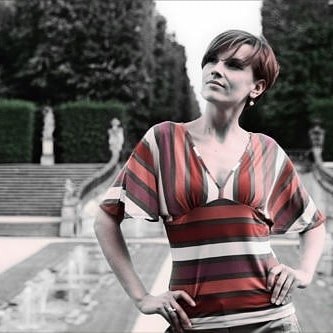 Frau in gestreiftem Kleid in einem barocken Park