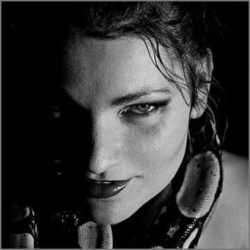 Schwarz-Weiß-Porträt einer Frau mit dunklem Blick, halb im Schatten