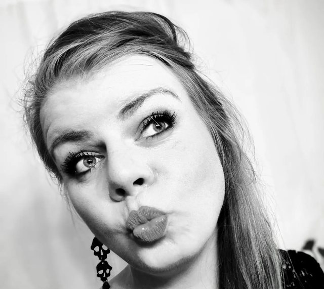 Schwarz-Weiß-Porträt einer Frau mit gespitzten Lippen