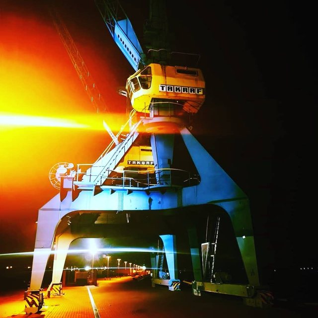 Hafenkran bei Nacht in leuchtenden Farben