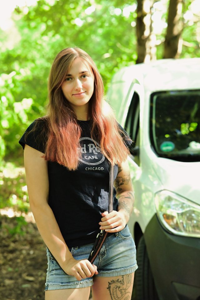 Lou mit Leine in der Hand vor dem Transporter