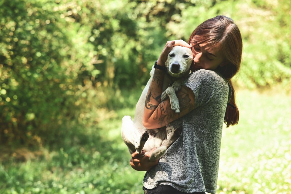 Lou drückt einen kleinen Hund an sich