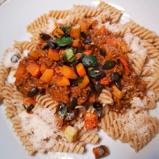 Kürbis-Hackfleisch Soße mit Parmesan auf Vollkorn Fusilli mit gerösteten Kürbiskernen