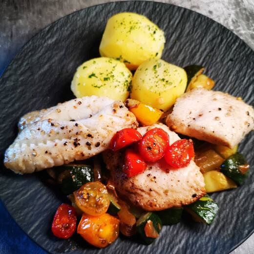 Fischfilet auf Zucchinibett an Salzkartoffeln und Grilltomaten
