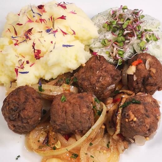 Bratfischröllchen dazu Zwiebelringe, Gurkensalat und Erdapfelmus