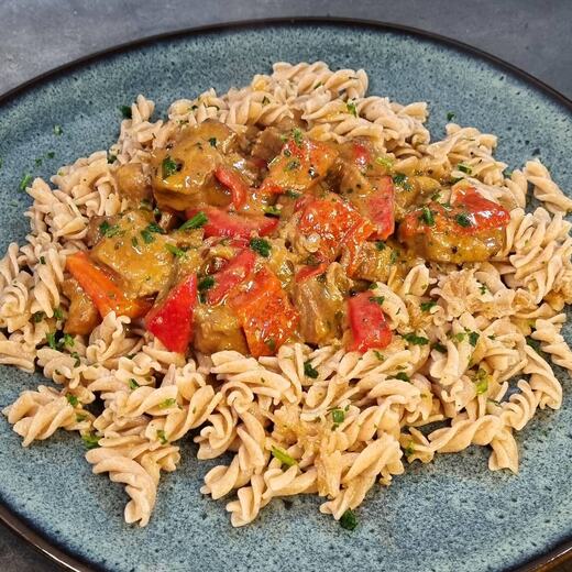 Dinkel-Vollkorn-Nudeln dazu Schweinegulasch mit Paprika und Zwiebeln