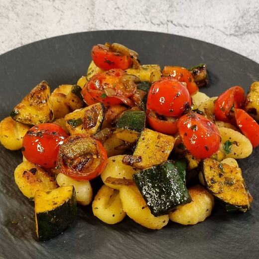 Schnelles Abendessen mit Gnocchi, frischen Kirschtomaten, Zucchini, Zwiebel und Kräutern