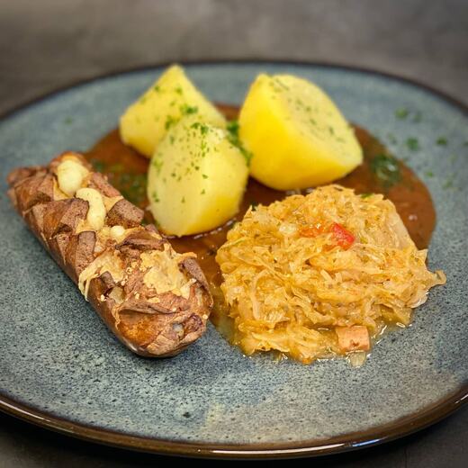 Überbackene Bratwurst mit pikantem Sauerkraut und Salzkartoffeln