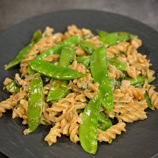 Vollkornnudeln mit Zuckerschoten und einer sanften Kokos-Mango-Sauce mit Wildkräutern verfeinert
