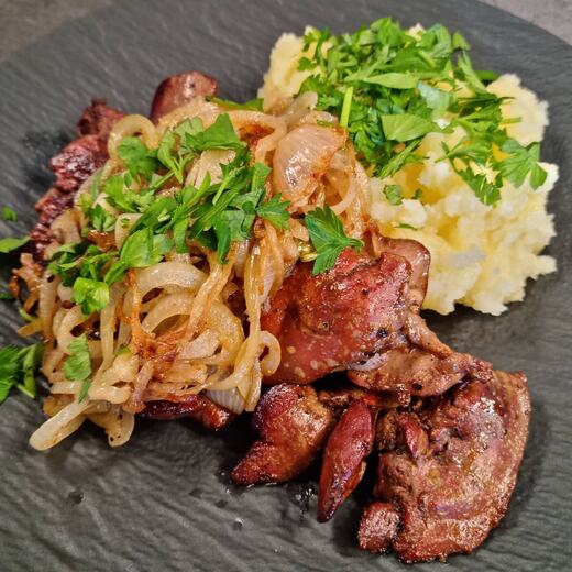 Marinierte Geflügelleber mit braunen Zwiebeln an frisch gestampftem Kartoffelbrei