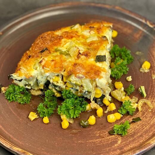 Zucchini-Speck-Bananen-Auflauf mit Mais, Käse, Zwiebeln, Eiern, Dinkelmehl, braune Butter und Sahne