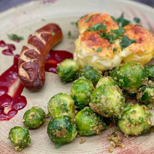 Bratwurst auf Felsenbirne-Heidelbeere-Soße an frischem Garten-Rosenkohl mit…